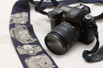 This photo of a film camera together with a tie showing different varieties of film cameras was taken by photographer Aschwin Prein of Barneveld, Netherlands.